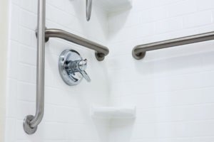 Accessible shower with grab bars and handheld showerhead.