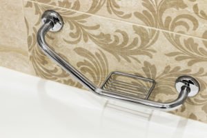 Chrome grab bar mounted on decorative bathroom tile.