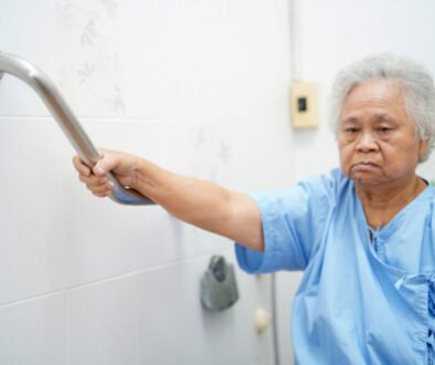 Senior woman using support handle in bathroom