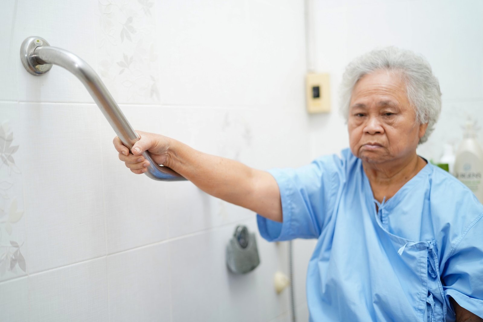 Senior woman using support handle in bathroom