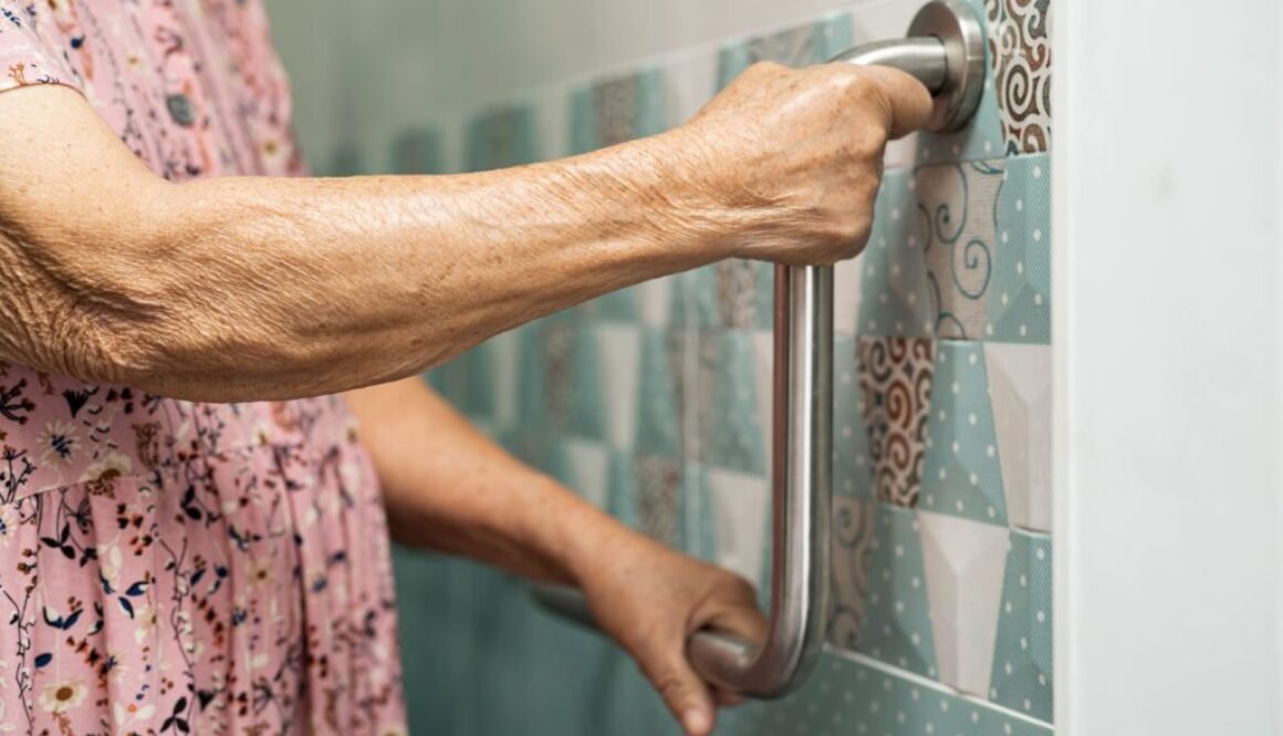 Hand gripping a bathroom safety grab bar