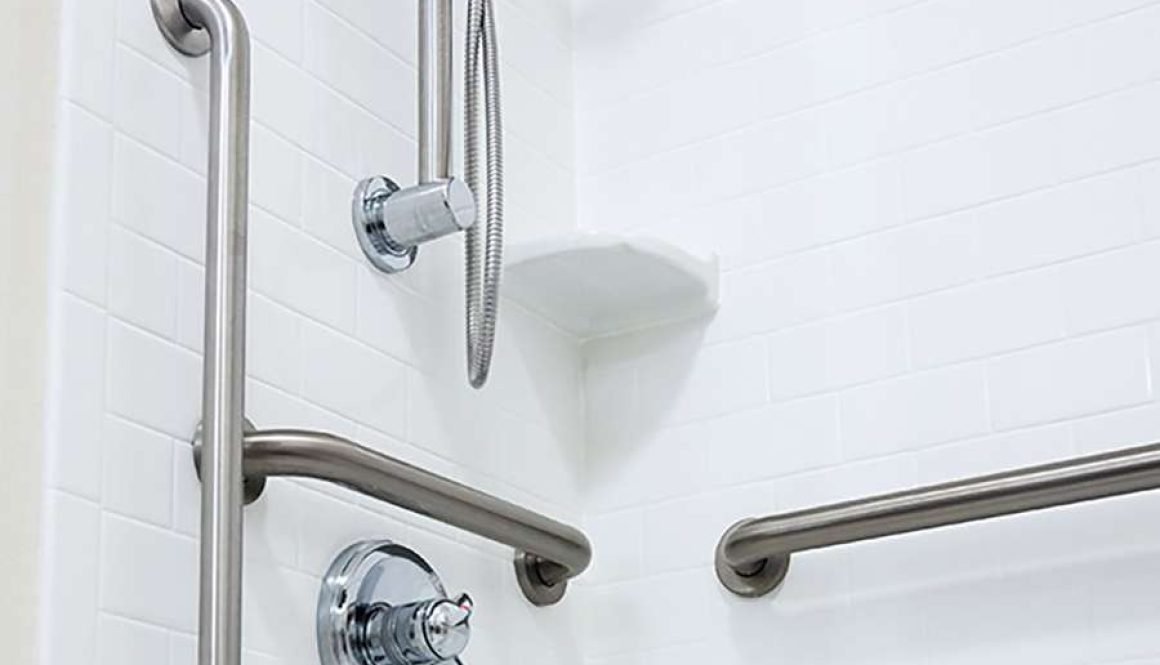 Accessible shower with grab bars and handheld showerhead.