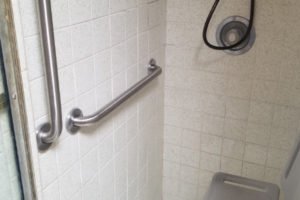 Accessible shower with grab bars and seat.