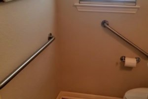 Accessible bathroom with grab bars and window.