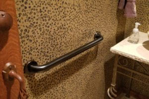 Bathroom grab bar mounted on leopard print wall