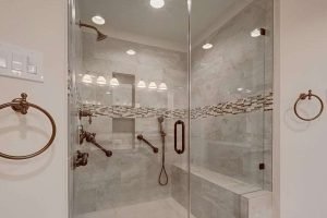 Modern glass shower with elegant fixtures and lighting.