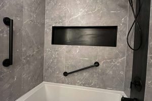 Modern bathroom shower with gray tiles and fixtures.
