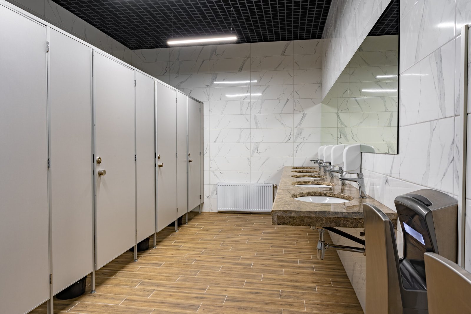Modern restroom with stalls and sinks.