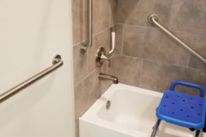 Accessible bathroom with grab bars and shower seat.