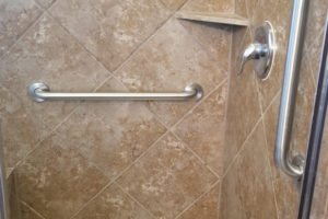 Accessible shower with grab bar and tile design.