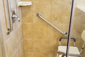Accessible shower with grab bars and seat.