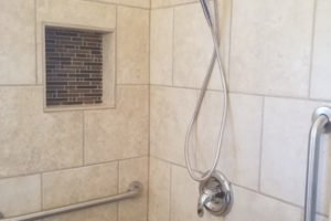 Stylish shower with tiles and adjustable showerhead.